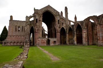 Nave (mostly ruined), choir (mostly intact) and cloister (left), viewed from west. Melrose Abbey, Melrose, Scotland.