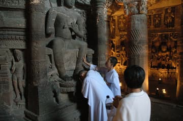 Buddhist monks honor an ancient sacred image.