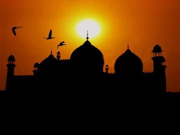 The graceful domes of Badshahi Mosque at sunset.