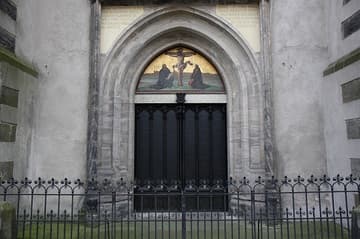 Sadly, the original wooden doors to which Luther posted his theses were destroyed in a 1760 fire. But to commemorate the 375th anniversary of Luther's birth in 1858, they were replaced with bronze doors that bear the Latin text of the 95 Theses. The painting in the tympanum was added at the same time. It depicts Luther and Melancthon kneeling before a Crucifixion against the backdrop of Wittenberg, with Luther holding his German Bible and Melancthon the Augsburg Confession.
