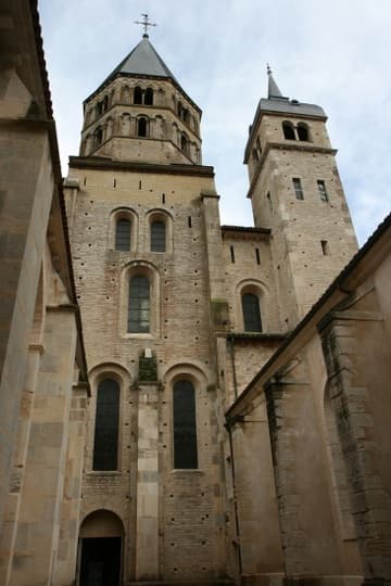 The best view in the house of the surviving south transept of Cluny Abbey (1088-1130), from the small Cour de la Congr&eacute;gation on its west side. The church was so monumental that each transept had two towers - the beautiful octagonal one is called the Clocher de l'Eau-B&eacute;nite ("Holy Water Belfry"). On the left is the outer wall of a side aisle; on the right is the 18th-century Chapel of the Congregation, which replaced the Romanesque "Abbot's Chapel."