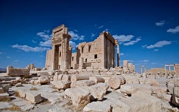 A dramatic view of the Temple of Bel and surrounding ancient fragments.