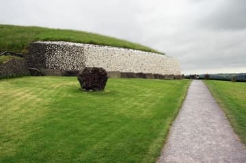 The path approaching Newgrange, with a single standing stone on the left. Newgrange is a prehistoric passage tomb and ceremonial chamber dating from about 3200 BC. Boyne River Valley, County Meath, Ireland.