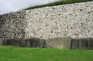Quartz facade and kerbstones to the left of the entrance at Newgrange, a prehistoric passage tomb and ceremonial chamber dating from about 3200 BC. Boyne River Valley, County Meath, Ireland.