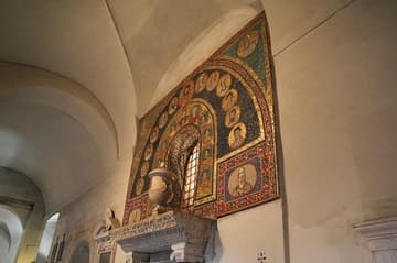 Exterior of the Chapel of St. Zeno, with 1st-century sculpture cornice, 3rd-century marble urn, and 9th-century mosaic. The mosaic features a double row of busts, with the Virgin Mary and Child, Prassede and Pudenziana in the inner row and Christ and the Apostles in the outer row. At the corners are four saints.