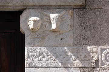 Marble reliefs, sculptures of animal heads and Latin inscription in the west facade next to the main door. Cattedrale di Santa Maria (1079-1104), Anagni, Lazio, Italy.