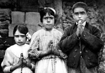 The young visionaries of Fatima - Jacinta, Francisco and Lucia (center) - pose with their rosaries in 1917. Public domain photo.