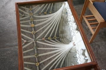 A closer look at the vaulted ceiling of the nave in a mirror set out in the central aisle.