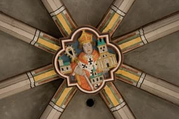 Painted roof boss in the nave, depicting a bishop with his churches.