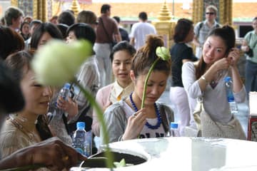 Prayers and dipping of lotus buds for good luck at Wat Phra Kaew.