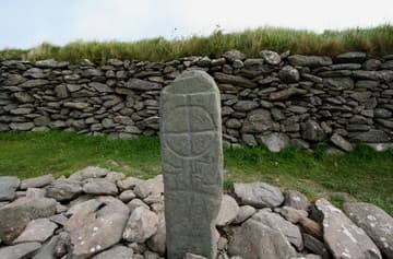 Cross marker with inscription next to the church.