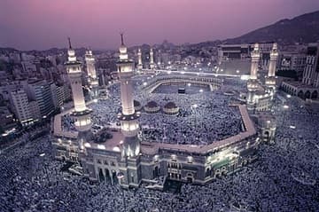 al-Haram Mosque and surrounding area at sunset, with every available space filled with Hajj worshippers.