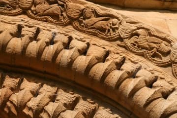 Detail of beakheads and figurative reliefs on the archivolts of the west portal. Iffley Church, 1170. Oxford, England.