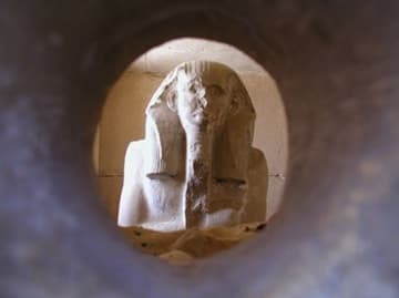Statue of Djoser viewed through an offering hole.
