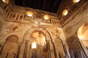 East wall of the baptistery, with Romanesque frescoes.