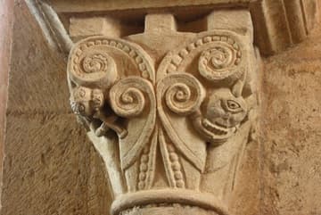 Romanesque capital (11th century) in Iguerande Church, Burgundy, France. On the right is a cyclops playing a pan flute, probably to teach the wickedness of profane music. The creature on the left may be playing a harp with its hooves.