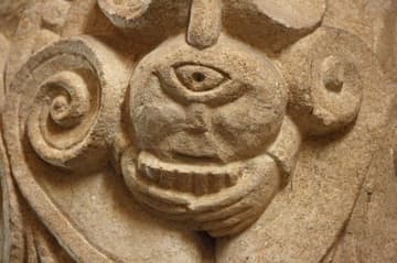 Romanesque capital (11th century) of a cyclops playing a pan flute in Iguerande Church, Burgundy, France. This wonderfully unique sculpture probably signifies the wickedness of profane music.