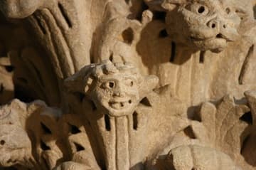 Heads sprout from acanthus leaves on a capital in the south arcade.