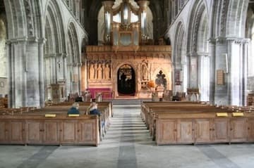 Interior from the west. The nave is the oldest surviving part of St. David's Cathedral, dating from the 12th century. Note the outward lean of the stone arcades! Straight ahead is the beautifully carved pulpitum or stone screen, which separates the nave from the choir.