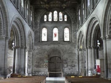 The nave of St. David's Cathedral, looking to the back (west). The arcade consists of alternate round and octagonal piers, with wide arches. The triforium is a light stone screen contained within the clerestory.