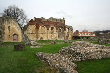 View from the southwest corner of the abbey church to the north wall of the Norman nave, which was walled up and converted into a palace for Anne of Cleves, the fourth wife of King Henry VIII, in 1539. The brickwork at the top is part of that Tudor conversion. In the right foreground is the south nave wall; the Ethelbert Tower is on the left.