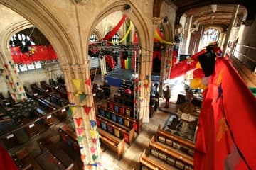 View from the south aisle towards the nave, with colorful decorations and platforms in place for a play.