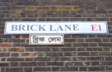 Bilingual Brick Lane sign on the side of the mosque.