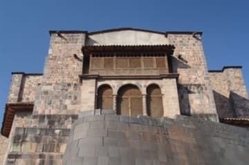 The perfect masonry of the curved Inca wall next to the Baroque church.