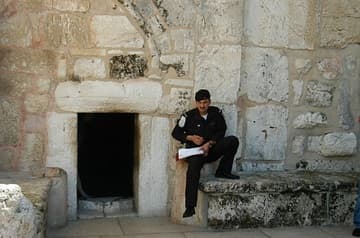 A Palestinian soldier rests outside of the Entry of Humility, Church of the Nativity, Bethlehem.