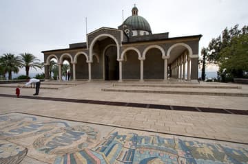 A sweeping view of the north side of the church, with the Sea of Galilee in the distance.