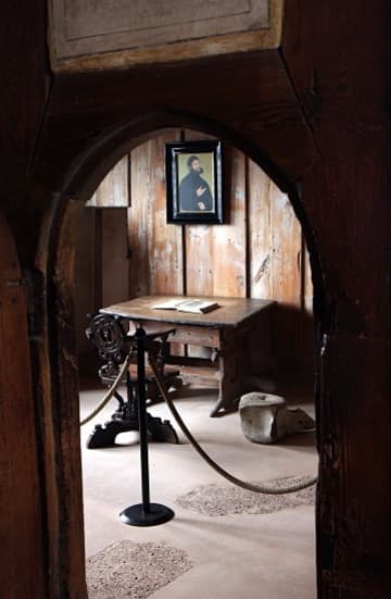 The Luther Room, with a facsimile of the September Testament and portrait of Luther in disguise at Knight George. The whale vertebra is the only original furnishing; Luther used it as a footstool.