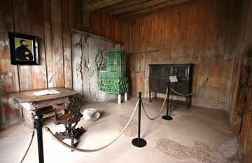 The Luther Room, with a facsimile of the September Testament and portrait of Luther in disguise at Knight George. The whale vertebra is the only original furnishing; Luther used it as a footstool.