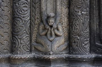 Jamb figure transforming solid stone grooves into pliable material.