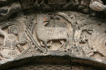 Lamb of God with symbols of St. Matthew the Evangelist (left) and St. John the Evangelist (right) on the central portal. 13th century. Ruvo di Puglia Cathedral, Puglia, Italy.