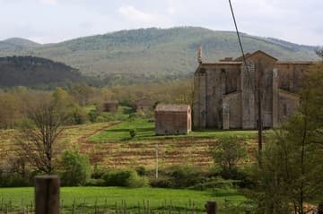 View of the abbey church and cemetery chapel from north, on the slopes of Montesiepi Hill. San Galgano Abbey, built by the Cistercians 1224-88. Tuscany, Italy.