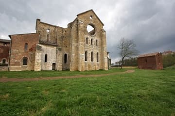 East facade of San Galgano Abbey, built by the Cistercians 1224-88. Also visible is a cemetery chapel of the same date (right foreground) and the Montesiepi Hermitage built in 1182 (right background). Tuscany, Italy.