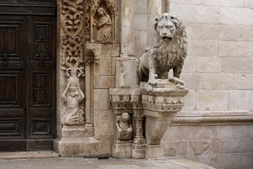 A typically Puglian lion guards the entrance.