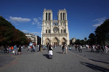 View of the beautiful, famous, and recently cleaned west facade of Notre Dame Cathedral.
