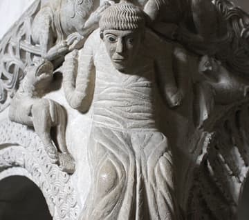 Detail of atlant (telamon) figure, possibly representing Daniel in the Lions' Den, on the southwest corner of the marble ambo. The ambo was made in the early 12th century (some sources say 1110, others 1143) and reconstructed after the roof collapsed in 1196. Sant'Ambrogio Basilica, Milan, Italy.