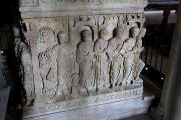 Detail of apostles on the Sarcophagus of Stilicone (385 AD) in the Basilica di Sant'Ambrogio, Milan, Italy. A magnificent work of Early Christian art, this sarcophagus is one of the few surviving elements from St. Ambrose's original basilica. It was carved during Ambrose's lifetime and its themes may have been suggested by the bishop himself. It still stands in its original location - the ambo was built around it. The tomb was probably commissioned by a high military official, who appears with his wife on the north side of the sarcophagus and again in a roundel on the lid. Their identities remain unknown; the name of the sarcophagus dates from the 18th century and is based on an erroneous tradition that it was made for Stilicone, a general who died in 408 in the service of Emperor Honorius. The sculptures on the sarcophagus are of exceptional quality, indicating they were carved by a Roman artist. It is called a "city gate sarcophagus" because of the prominent city walls and gates within the scenes.