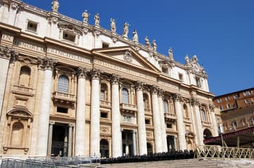 The grand east facade of St Peter's Basilica, 116 m wide and 53 m high. Built from 1608 to 1614, it was designed by Carlo Modeno. The central balcony is called the Loggia of the Blessings and is used for the announcement of the new pope with "Habemus Papum" and his Urbi et Orbi blessing. The relief under the balcony, by Buonvicino, shows Christ giving the keys to St. Peter. The facade is topped by 13 statues of apostles in travertine. The dome was designed by Michelangelo and completed in 1593.