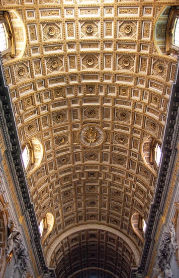 Opulent ceiling of the central nave. The pilasters on either side feature two levels of statues of saints who founded religious orders.