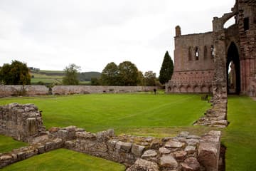 Cloister and church, viewed from west. Ruins of Melrose Abbey, Melrose, Scotland.
