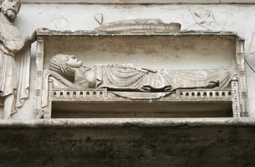 The Virgin Mary in bed after the birth of Christ, who has mostly disappeared from the upper part of the scene. Joseph stands by on the left. Detail of the west portal or Royal Portal, completed by 1150. Its celebrated sculptures show the transition from Romanesque to Gothic.