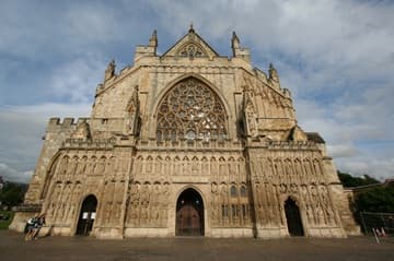 The magnificent west front of Exeter Cathedral is covered with a Decorated Gothic image screen, which was begun in the 1340s and completed nearly a century later. It features three tiers of very weathered sculptures, which include the rulers Alfred, Athelstand, Canute, Willliam the Conqueror and Richard II, as well as saints. The images were originally brightly painted.