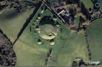 Aerial view of Knowth oriented north. The passage entrances can be seen on west and east; the visitor's access chamber is the slit on the SE.