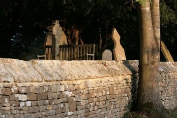 Evening light on the stone wall outside St Nicholas' Church, Oddington.