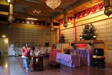 Main temple hall, with Kwan Yin shrine and plaques covering the wall.