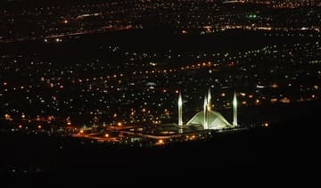 View of Faisal Mosque from the hills at night.