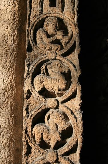 Detail of the Prior's Door in the south aisle of the nave, a magnificent example of 12th-century Romanesque carving. Dating from about 1150, its tympanum depicts Christ in Majesty held aloft by archangels and blessing the creatures of the universe. Two human heads peer down from the corners and the pillasters on the sides have medallions populated by various beasts and humans.